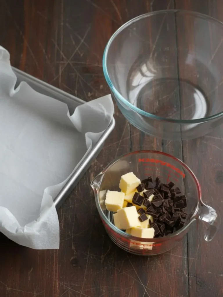 Fudgy Homemade Brownies Step 1 for seriously fudgy homemade brownies with the parchment-lined square metal pan prepared and butter with chopped chocolate ready to melt